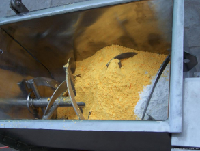 A large metal container filled with yellow powder.