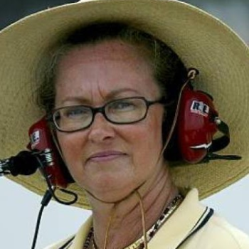 A woman wearing headphones and holding onto two large speakers.