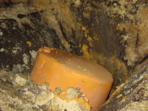 A piece of orange soap sitting in the middle of a pile.